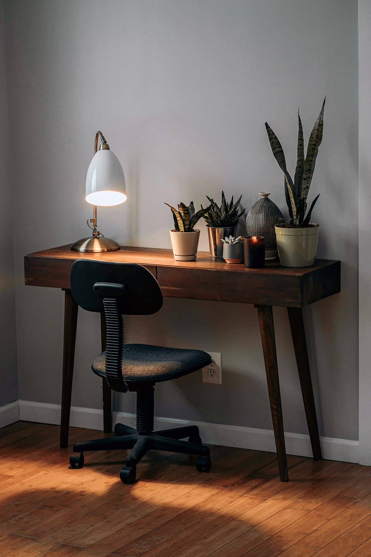 Un bureau avec une lampe et des plantes, illustrant l'intégration de l'environnement dans l'espace de travail