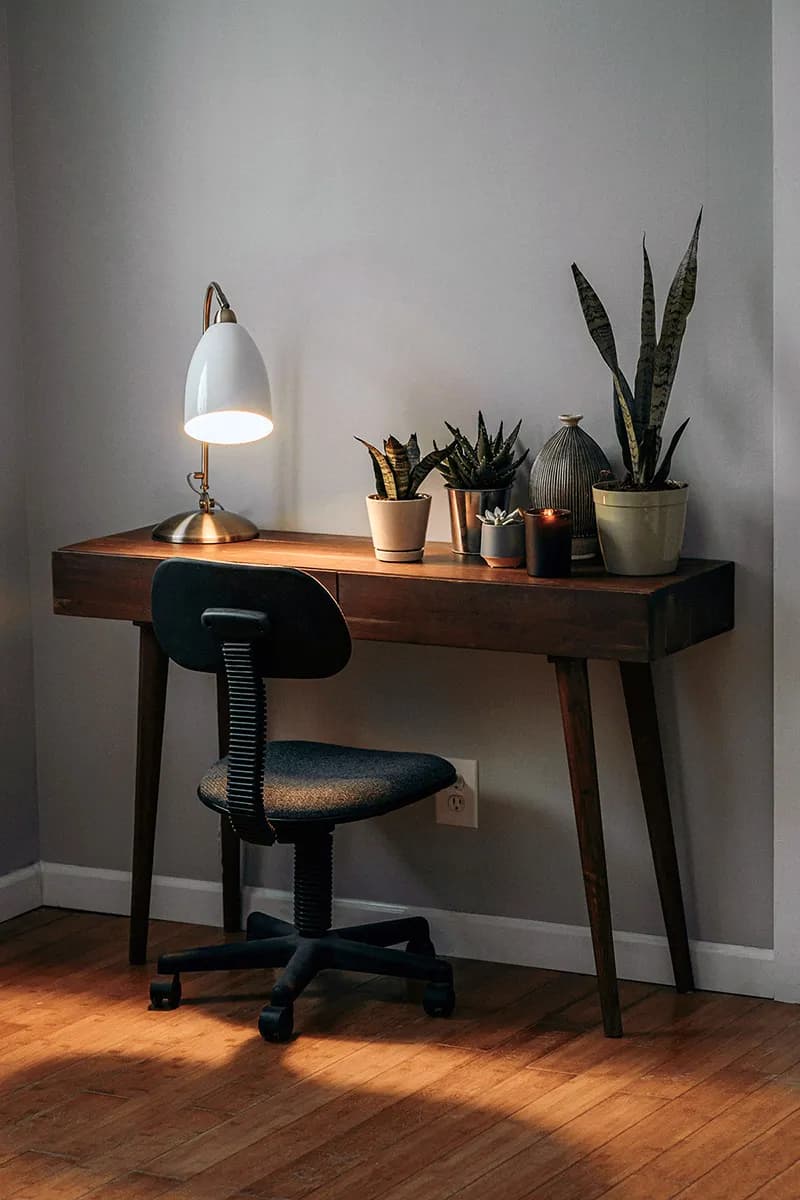 Un bureau avec une lampe et des plantes, illustrant l'intégration de l'environnement dans l'espace de travail