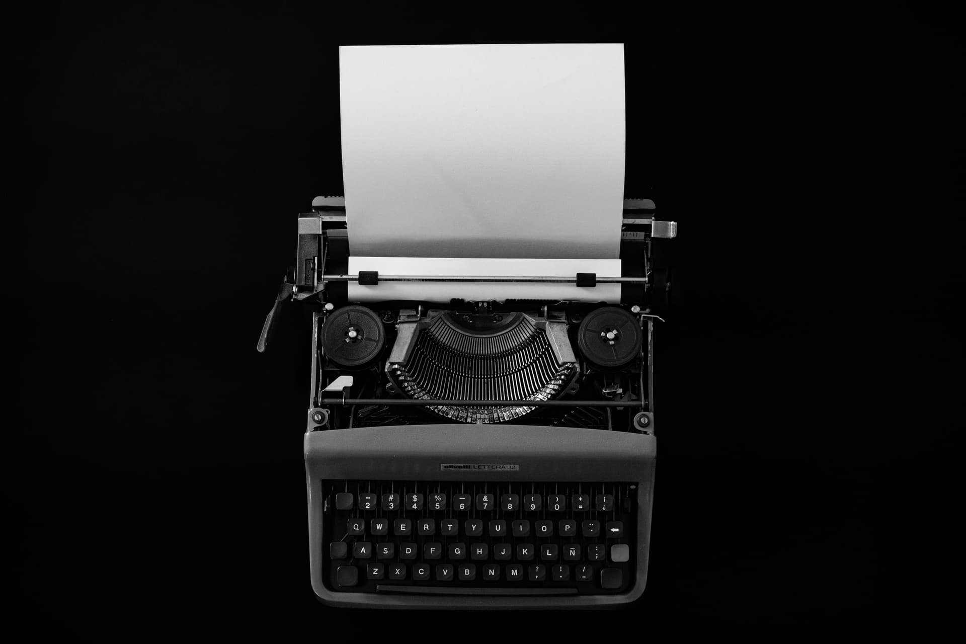 Machine à écrire face à une page blanche, illustrant le contrôle manuel du texte et des espaces
