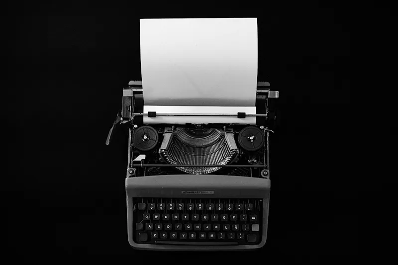 Machine à écrire face à une page blanche, illustrant le contrôle manuel du texte et des espaces