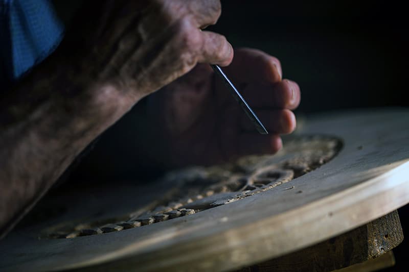 Gros plan sur les mains d'un artisan au travail, représentant la préservation de la touche humaine