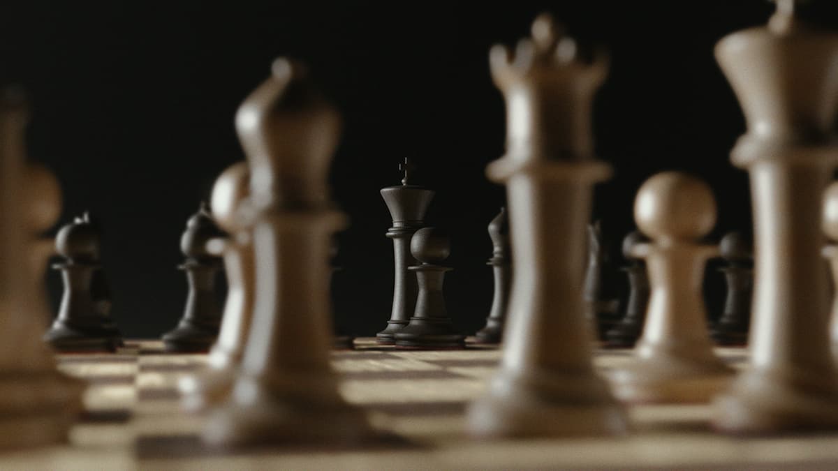Des pièces d'échecs sur un plateau sombre, illustrant la stratégie et la réflexion posée