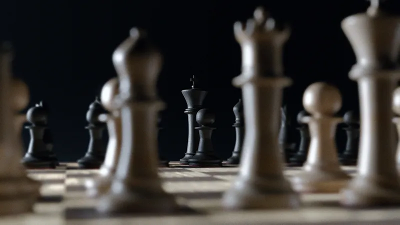 Des pièces d'échecs sur un plateau sombre, illustrant la stratégie et la réflexion posée