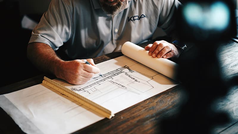 Plans d'architecte sur une table, illustrant la structuration algorithmique de la pensée brute