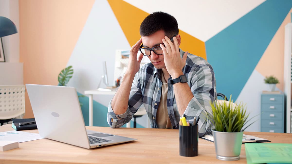 Personne hésitant devant son ordinateur avant de publier sur les réseaux sociaux