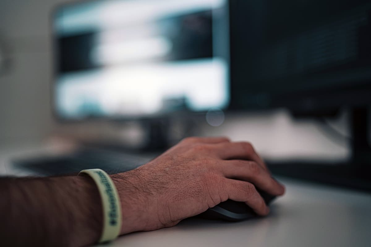 Gros plan sur la main d'une personne utilisant une souris d'ordinateur sur un bureau, symbolisant le clic sur un Call-to-Action