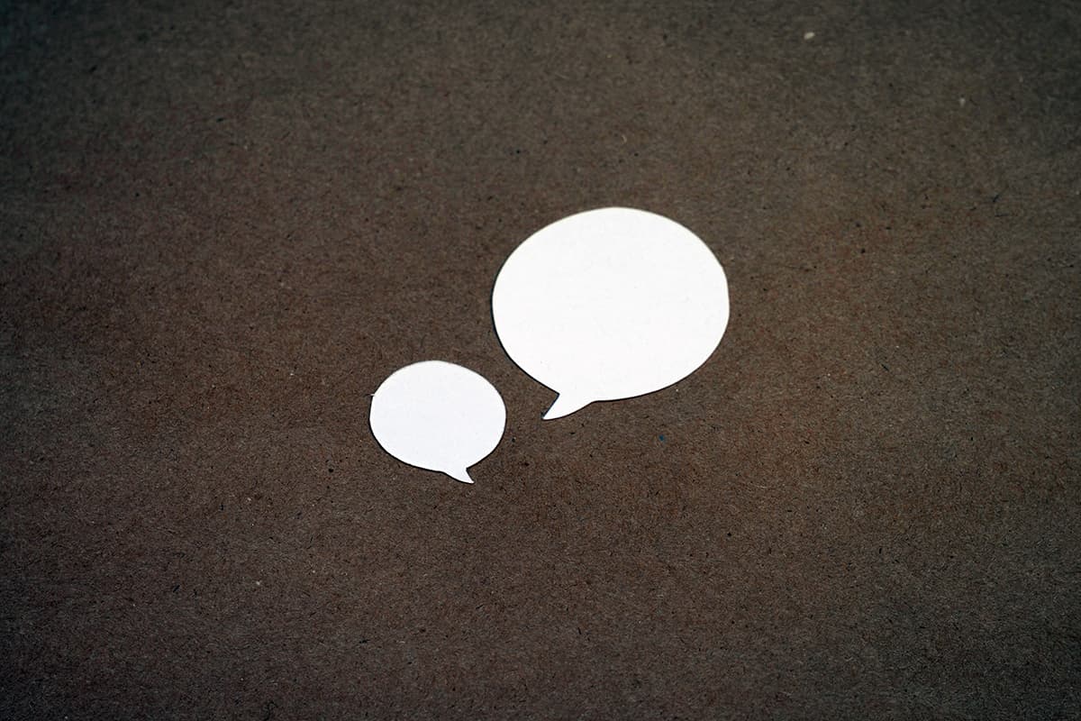Deux bulles de dialogue blanches sur une surface brune, symbolisant les retours clients