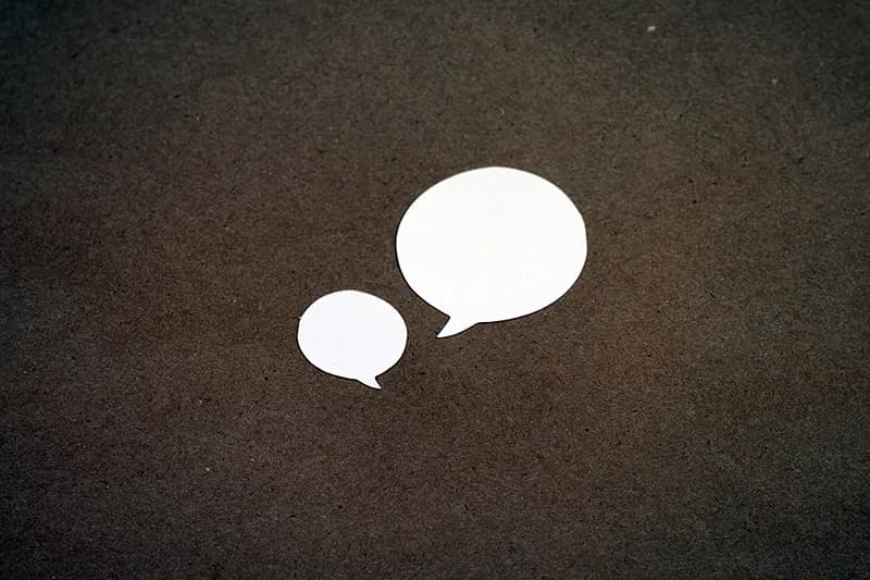 Deux bulles de dialogue blanches sur une surface brune, symbolisant les retours clients