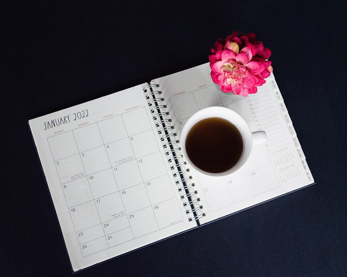 Tasse de café sur un bureau à côté d'un calendrier pour planifier sa semaine