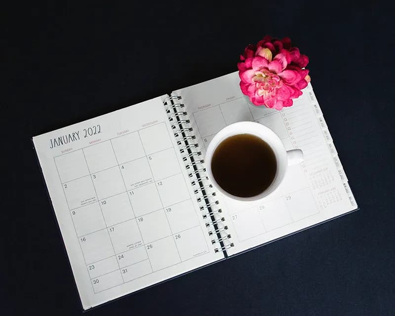 Tasse de café sur un bureau à côté d'un calendrier pour planifier sa semaine