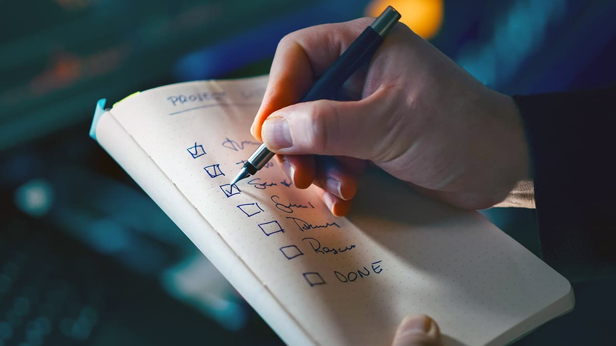 Main cochant des tâches sur une to-do list de gestion du temps