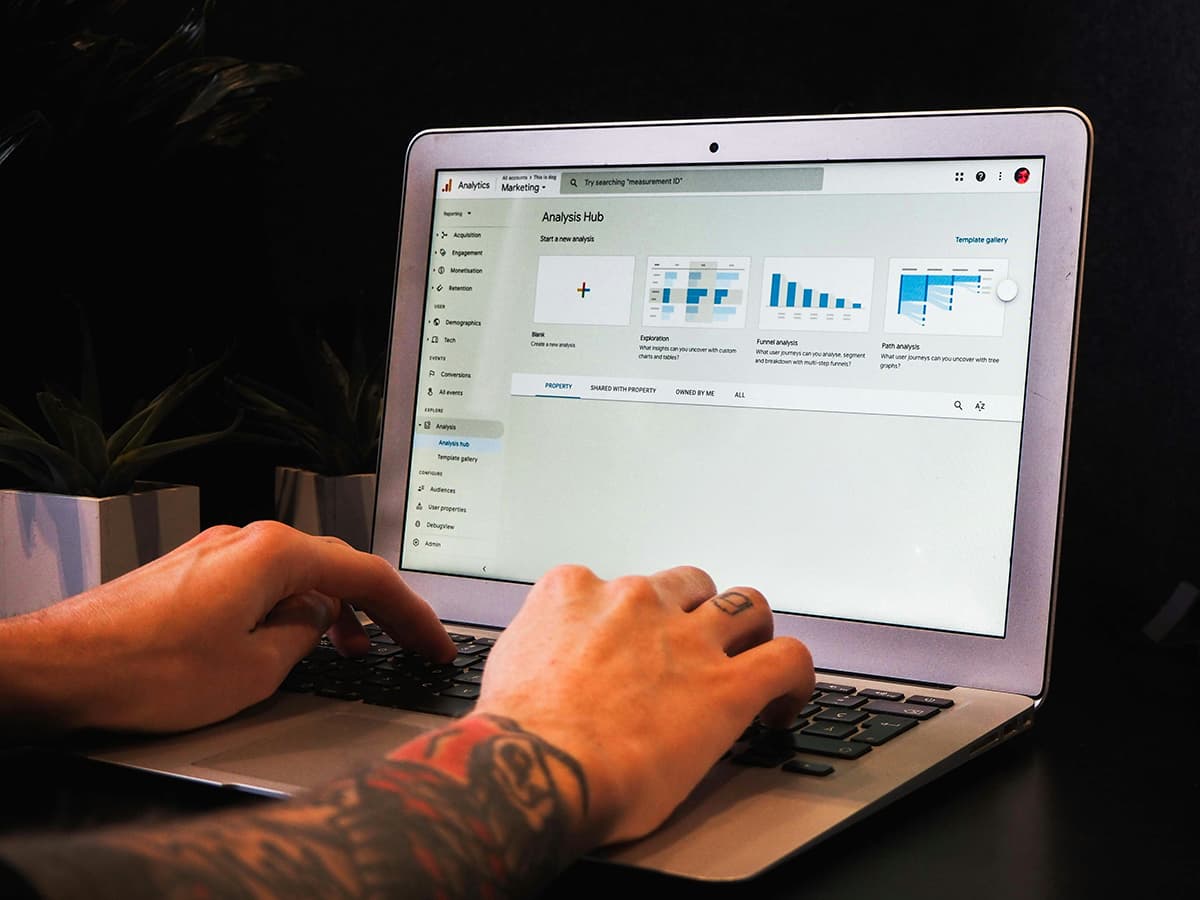 Personne analysant le trafic d'un site web sur Google Analytics depuis un ordinateur portable