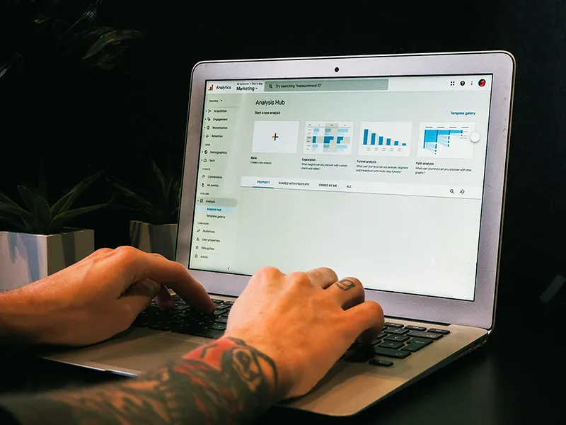 Personne analysant le trafic d'un site web sur Google Analytics depuis un ordinateur portable