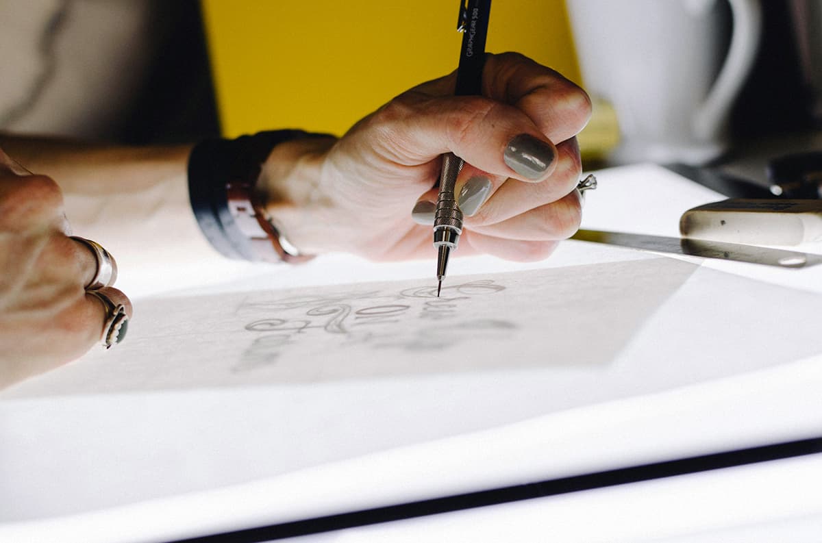 Designer traçant des lettres sur une table lumineuse