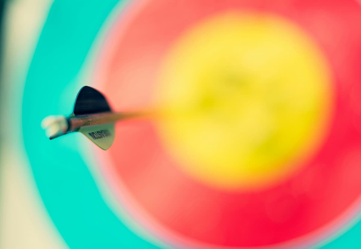 Une flèche plantée exactement au centre d'une cible, symbolisant la précision et le focus d'une idée
