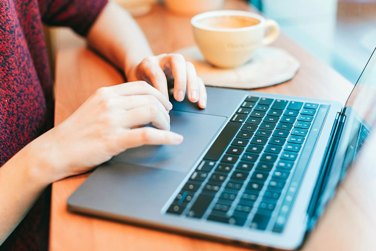 Gros plan sur les mains d'une personne tapant sur le clavier d'un MacBook Pro