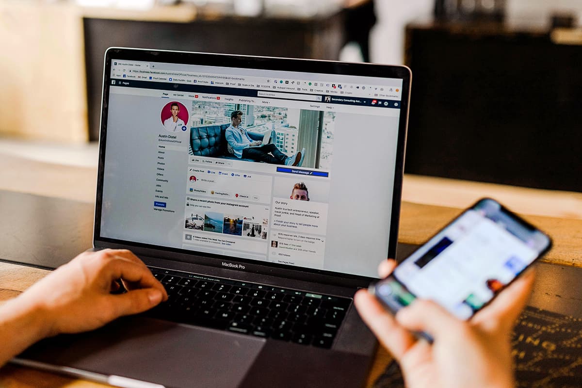 Un entrepreneur gère ses réseaux professionnels sur son ordinateur et son smartphone en même temps