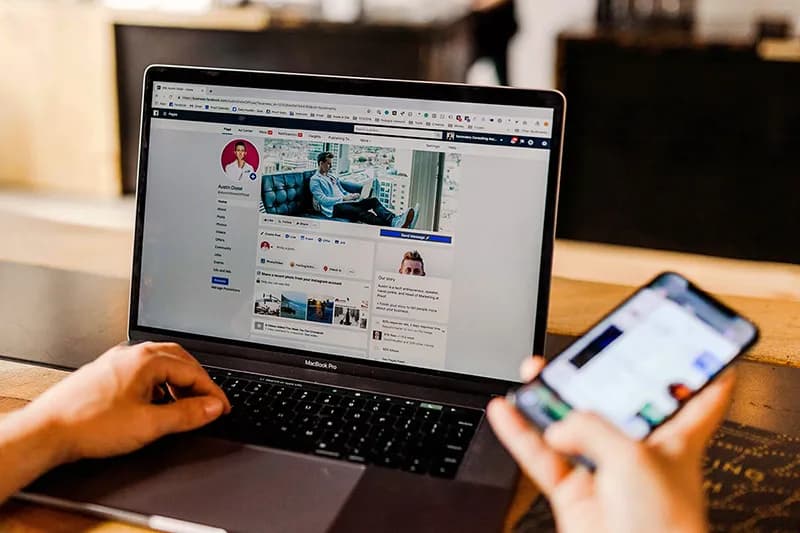 Un entrepreneur gère ses réseaux professionnels sur son ordinateur et son smartphone en même temps