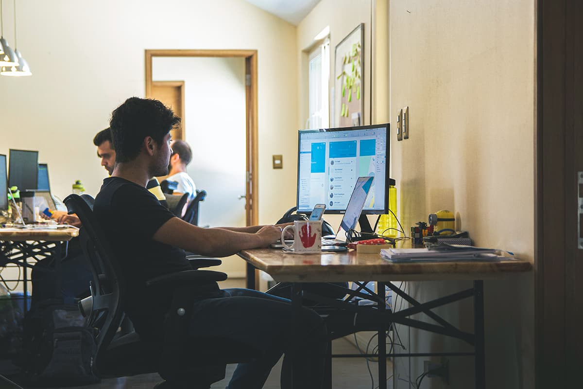 Homme travaillant intensément sur un moniteur d'ordinateur