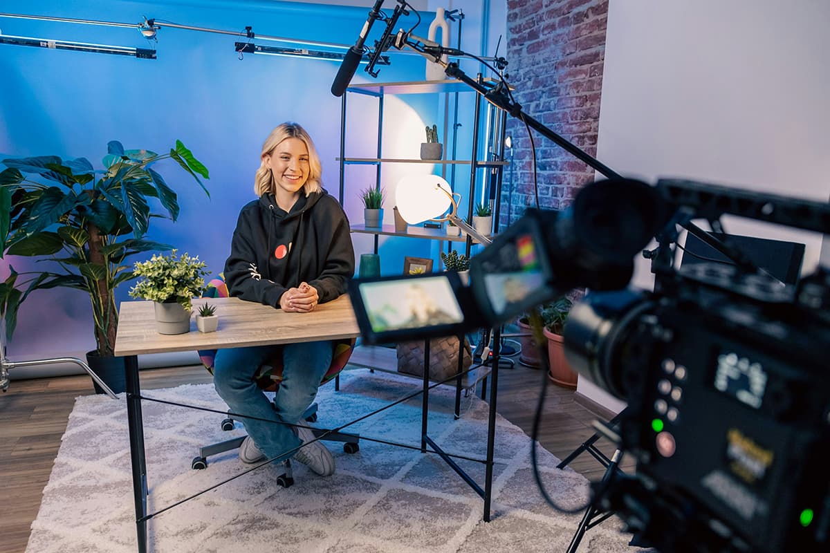 Une personne assise devant une caméra dans un studio de production vidéo, illustrant la création sur YouTube