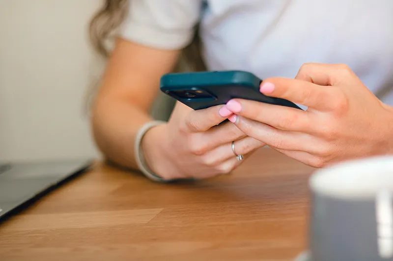 Personne naviguant sur les réseaux sociaux avec son smartphone